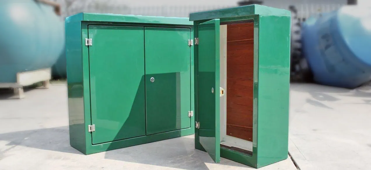  Green GRP electrical enclosure on a forecourt. One closed and another open.